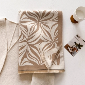 Detail of winter scarf with abstract brown floral pattern and fringe edge texture