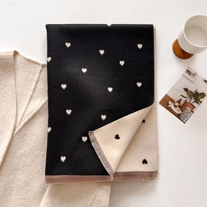 Close-up of double-sided heart pattern scarf with delicate fringe edges and soft knit texture