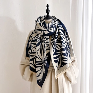 Navy and cream thick winter scarf with vintage floral print and tassels on a model