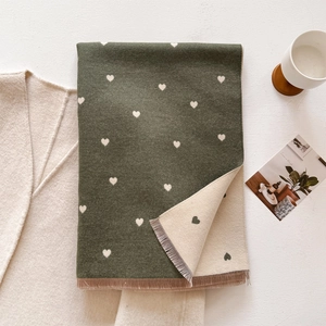 Detailed view of the soft cashmere-like heart pattern knit scarf with tassel fringe edges