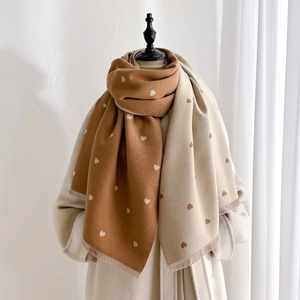 Detail of double-sided heart pattern scarf with soft cashmere-like texture and fringes