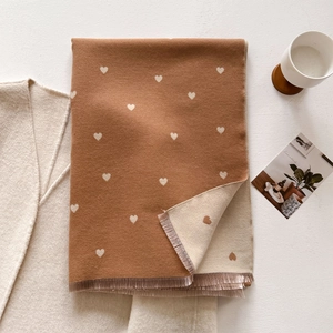 Close-up of double-sided heart jacquard scarf with soft cashmere feel and fringe detail
