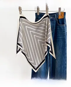 Detail of soft striped silk scarf with contrast piping edges paired with denim