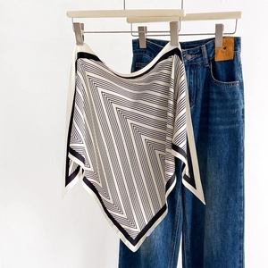 Classic black and white striped triangle scarf styled on denim for a trendy spring look