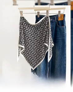 Close-up of black and white paisley triangle scarf paired with classic denim jeans