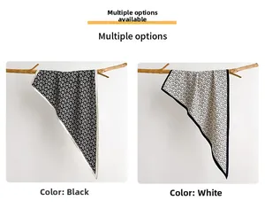 Close-up of black and white paisley silk scarves with floral patterns on dried branches