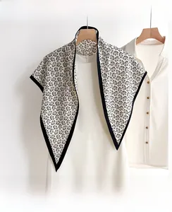 Detail of black and white paisley silk scarf with delicate floral print and draped texture