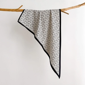Black and white paisley silk scarf draped on a branch for minimalist fashion styling