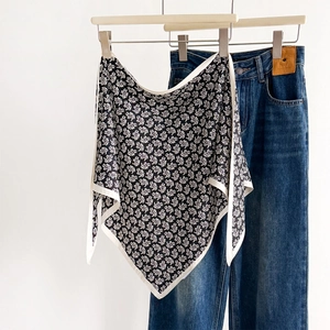 Classic black and white paisley silk scarf displayed on a minimalist white background