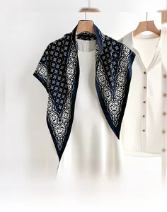Close-up of geometric pattern print on thin navy blue triangular scarf and silk fabric
