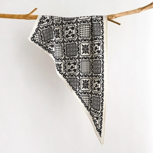 Detail of vintage black and white silk scarf hanging on a natural wooden branch