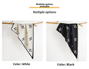 Close-up of floral and polka dot silk scarves in white and black colors on rustic branches