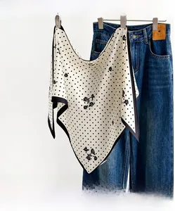 Detailed texture of a silky floral polka dot neck scarf paired with casual blue denim