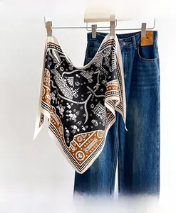 Detail of vintage geometric silk scarf draped on denim background for professional styling