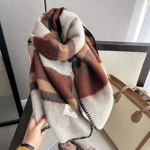 Detailed view of thick houndstooth scarf texture with high-quality logo woven label