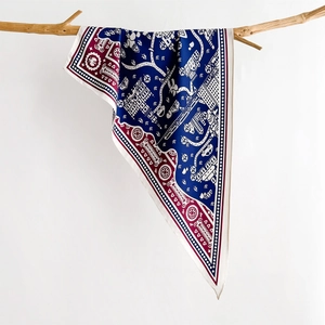 Silk neck scarf with blue and red city map print hung on a wooden branch