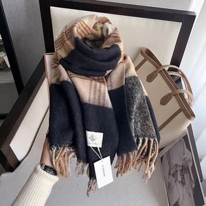 Close-up of thick houndstooth scarf with long tassels and premium texture detail
