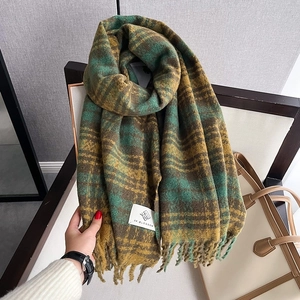 Detailed macro view of vintage thick knit houndstooth scarf with soft fringe and logo patch