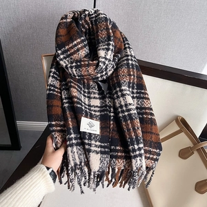 Close-up of houndstooth scarf texture with long tassels and branded woven label
