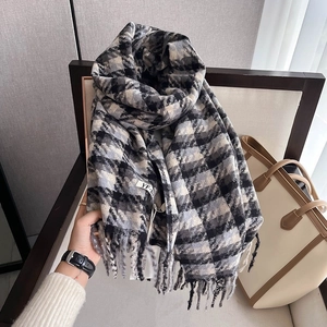 Detail view of the black and grey houndstooth scarf texture with fringed tassel edges