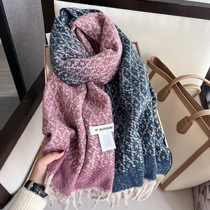 Close-up of houndstooth knit scarf texture in navy and lilac with soft fringe detail