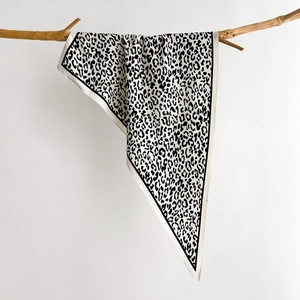 Eleganter Seidenschal mit Leopardenmuster in Schwarz-Weiß und glatter Satin-Textur am Zweig