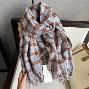 Close-up of houndstooth scarf with long tassels and thick knitted cashmere texture