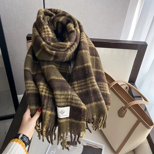Detail of classic houndstooth plaid scarf with soft fringe and stylish brand tag