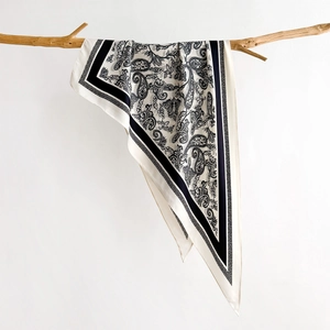 Elegant cream paisley silk scarf hanging on a natural branch for stylish spring accessories