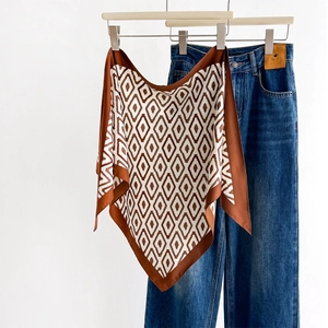 Spring silk scarf with brown and white geometric diamond print draped on hanger
