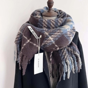 Classic houndstooth thick winter scarf with soft fringes shown on a black wool coat