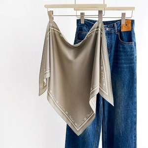 Classic vintage square silk scarf with letter print styled with denim jeans on white backdrop