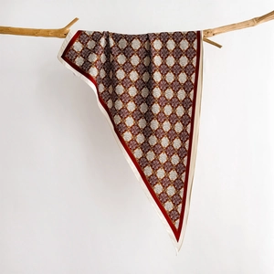 Detail of vintage striped silk scarf with geometric floral patterns on a wooden branch