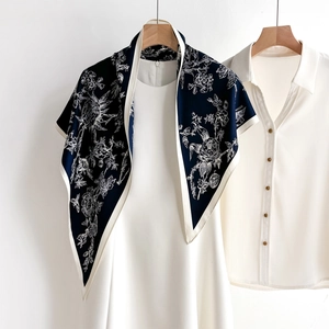 Elegant navy blue floral silk scarf with white bird prints styled on a white dress