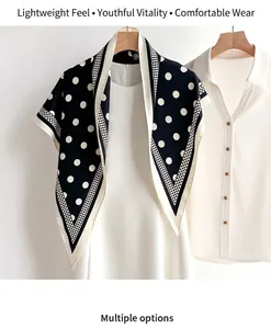 Detailed view of polka dot silk scarf featuring soft texture and elegant checkered borders