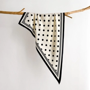 Polka dot silk scarf draped on a wooden branch with soft lighting for a minimalist aesthetic