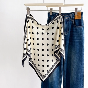Silk neckerchief with black polka dots on cream background styled with denim jeans