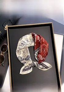 Dettaglio macro di un foulard in seta 100% con motivo paisley su una borsa elegante