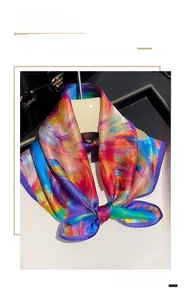 Detail view of 53cm silk scarf featuring colorful floral patterns and 100% mulberry silk