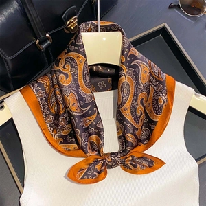 Retro paisley print silk scarf in orange and brown paired with a white knit top