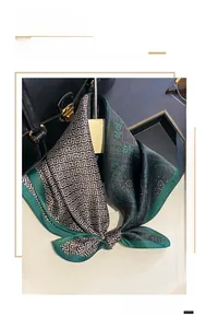 Detail of 100% silk scarf with green paisley and black geometric patterns on a handbag