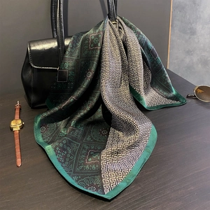 Vintage mulberry silk square scarf with green paisley print draped over a black leather handbag