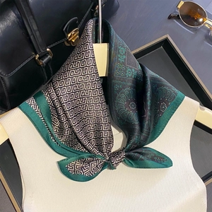 Green and black paisley silk scarf featuring vintage geometric patterns in a bowtie style