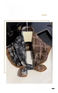 Detail of silk scarf with paisley and geometric patterns in black and brown silk