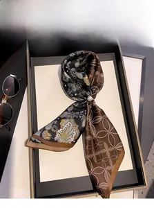 Detail of 100% silk scarf with paisley pattern and elegant pearl ring buckle accessory