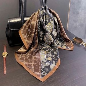 Vintage paisley print mulberry silk scarf elegantly draped on a black leather handbag