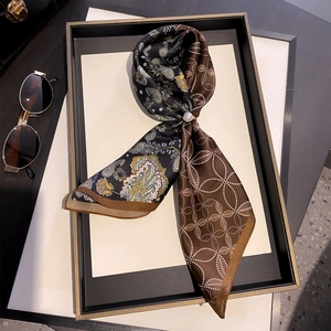 Retro paisley silk scarf with pearl slide buckle and geometric patterns on a tray
