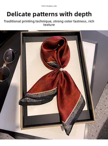 Dettaglio foulard in seta con motivo paisley, bordo leopardato e accessorio con perla