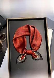 Dettaglio di un foulard in seta rossa paisley come elegante accessorio per capelli e capo