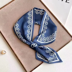 Elegant navy blue silk scarf with white interlocking geometric patterns and satin finish